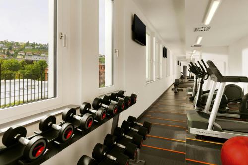 a gym with rows of exercise bikes and a treadmill at Aloft Stuttgart in Stuttgart