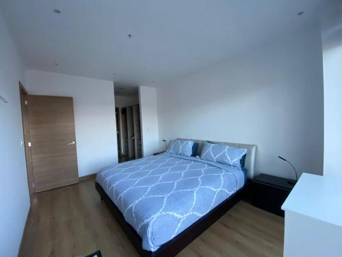 ein Schlafzimmer mit einem Bett mit einer blauen Bettdecke in der Unterkunft Premium Suite República del Salvador in Quito