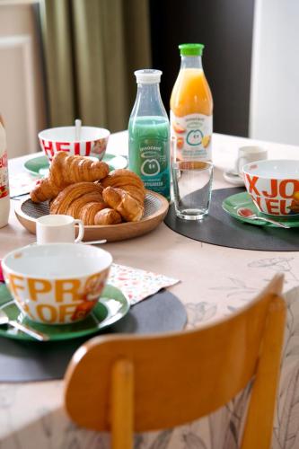 a table with a plate of pastries and bottles of juice at Le Familia in Guer