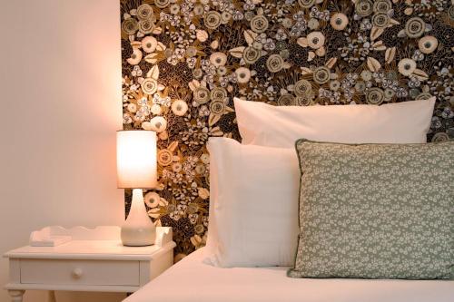 a bedroom with a bed with a floral wall at Le Familia in Guer