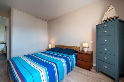 1 dormitorio con 1 cama azul y vestidor azul en Residence mer et pins, en Saint-Philibert