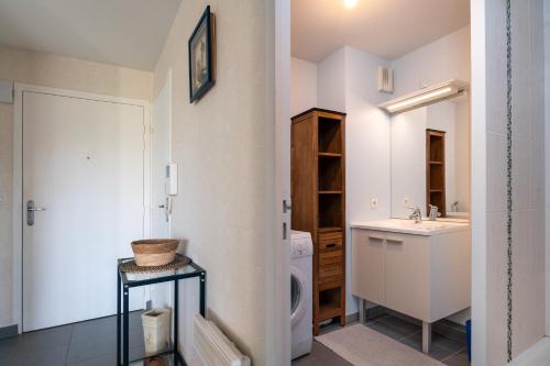 Un baño con lavabo y lavadora. en Residence mer et pins, en Saint-Philibert