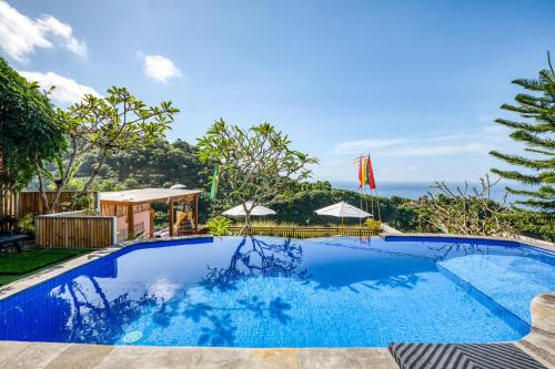 a swimming pool at a resort with a view of the ocean at Adinata Villa by Manara in Seraya