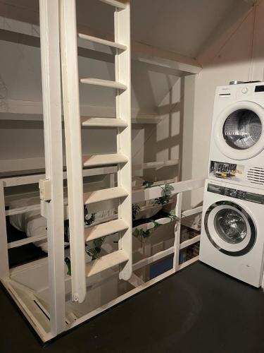 a laundry room with a washer and a washing machine at Cozy Studio in the heart of the village in Hippolytushoef