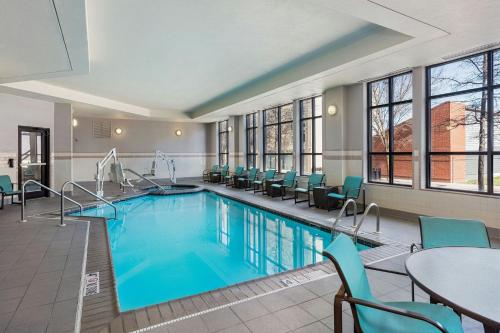 a pool in a hotel room with chairs and a table at Residence Inn Louisville Downtown in Louisville