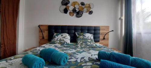 a bedroom with a bed with blue pillows at Villa bord de mer - Piscine privée in Les Trois-Îlets