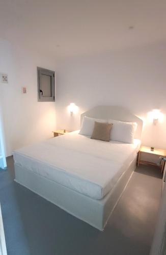 a large white bed in a room with two lamps at Kanala Sea View in Kanala