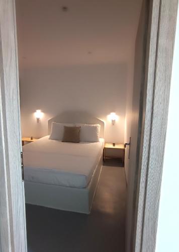 a bedroom with a white bed and two lamps at Kanala Sea View in Kanala