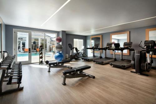 a gym with several treadmills and machines in a room at Aloft Mountain View in Mountain View