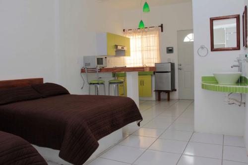 a bedroom with a bed and a kitchen with a sink at Hotel y Suites Del Paci­fico in Salina Cruz