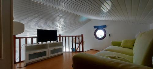 a living room with a couch and a flat screen tv at Villa bord de mer - Piscine privée in Les Trois-Îlets