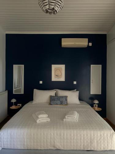 a bedroom with a large bed with a blue wall at Sea You Soon & Spa 1 in Methana