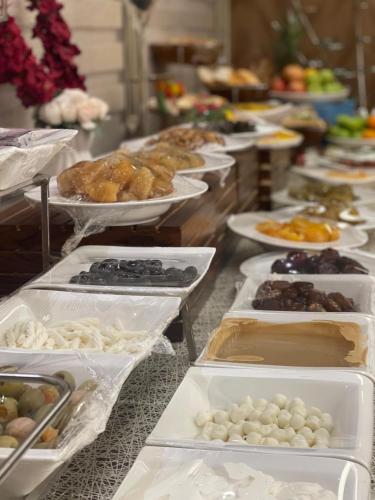 a buffet with many different types of food on trays at Granada Hotel in An Najaf