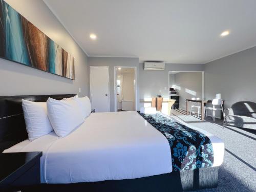 a bedroom with a large white bed in a room at Camelot On Ulster in Hamilton
