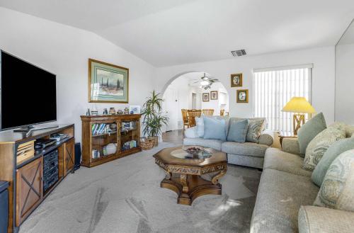 a living room with a couch and a tv at Stylish Condo with Private Pool & & Panoramic View in Palm Springs