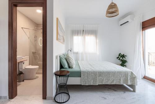 a white bedroom with a bed and a bathroom at MUSES CHALKIDIKI #Skgbnb in Mesochórion