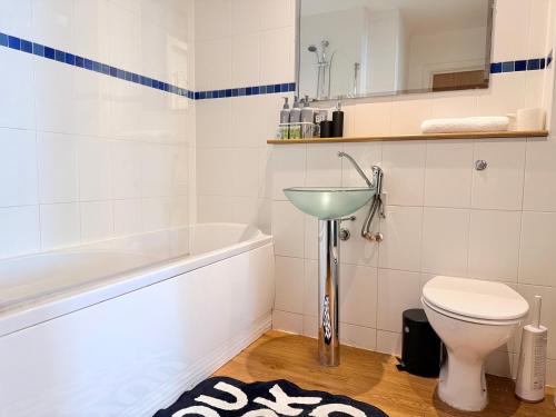 a bathroom with a sink and a toilet and a bath tub at PostBox Apartments in Birmingham City Centre Near Birmingham Canal in Birmingham