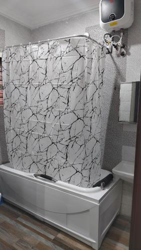 a bathroom with a white and black shower curtain at Keev Homes 2 bedroom Apartment in Port Harcourt