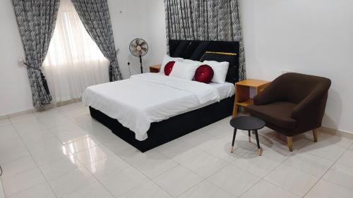 a bedroom with a bed and a chair at Keev Homes 2 bedroom Apartment in Port Harcourt