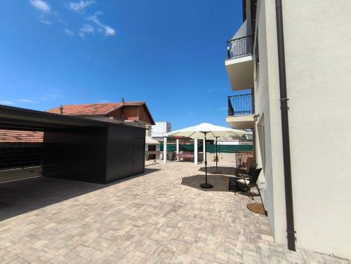 a patio with a table and an umbrella at Apartmani la Barquera in Brodarica