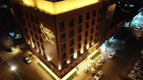 a large building with a sign on it at night at Granada Hotel in An Najaf