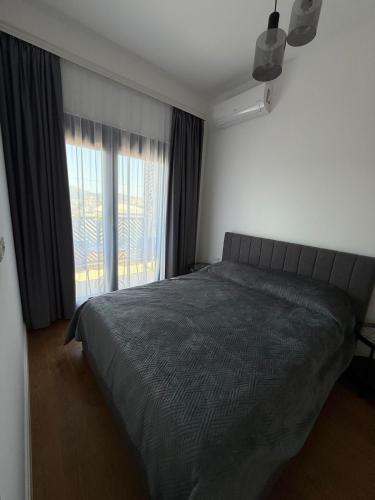 Un dormitorio con una cama y una ventana grande. en Bar Seaview Escape, en Bar