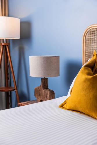a bed with a lamp and a pillow on it at The Lucky Hotel in Newcastle