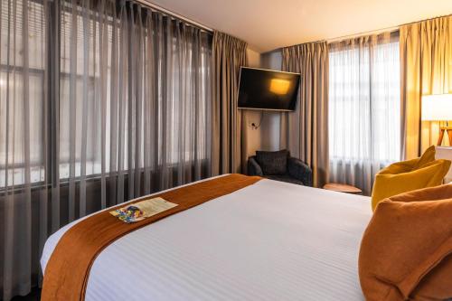 a hotel room with a large bed and a television at The Lucky Hotel in Newcastle