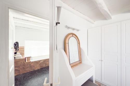 a white bathroom with a mirror and a sink at Eagles Nest Mykonos in Tourlos
