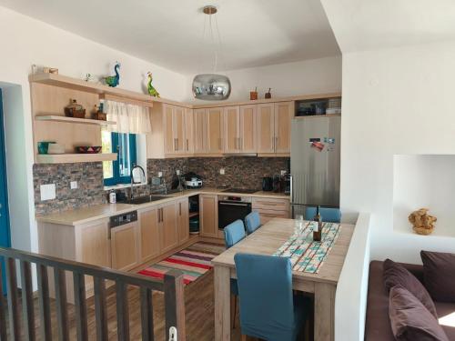 a kitchen with wooden cabinets and a table with blue chairs at Kedros in Lipsoi