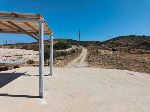 a shelter with a dirt road in the background at Kedros in Lipsoi
