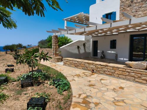 a house with a stone walkway in front of it at Kedros in Lipsoi