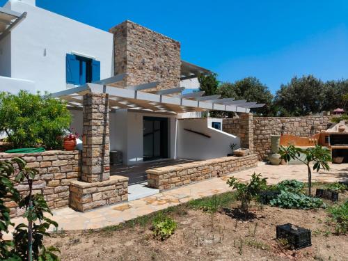 a white house with a stone wall at Kedros in Lipsoi