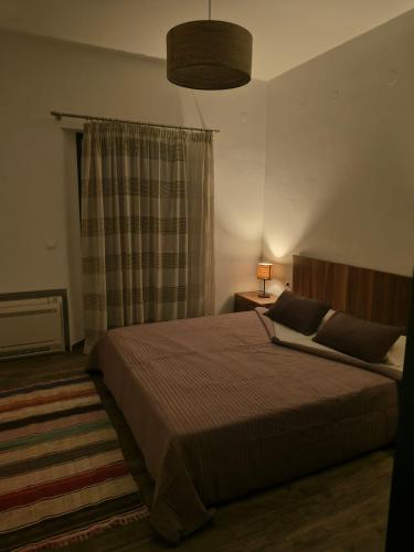 a bedroom with a large bed and a lamp at Kedros in Lipsoi