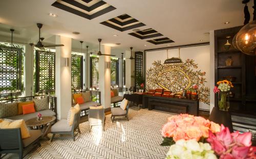 a lobby with a fireplace and chairs and a table at Shinta Mani Angkor in Siem Reap