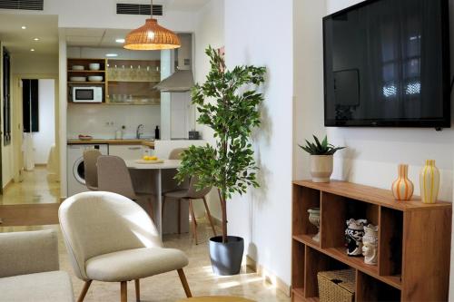 a living room with a table and a tv on a wall at AvantiStays Capote in Seville