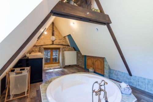 a bathroom with a large tub in the attic at Maison de campagne dans le Périgord in Anlhiac