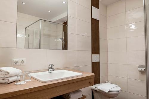 a white bathroom with a sink and a toilet at DIE BARBARA Appartements & Zimmer in Schladming