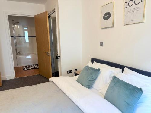 a bedroom with a bed with blue and white pillows at PostBox Apartments in Birmingham City Centre Near Birmingham Canal in Birmingham