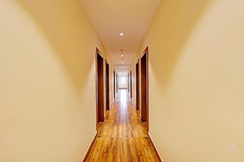 a hallway with wooden floors and white walls at FabHotel Siddarth in Vijayawāda