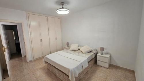 a white bedroom with a bed and a white cabinet at Atlantic Blue Dream Caletillas in Araya