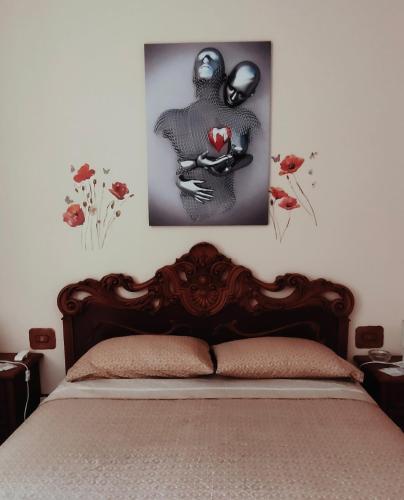 a bedroom with a bed with two pictures on the wall at Camera a Catanzaro in villa relax ""oasi verde"" in Catanzaro