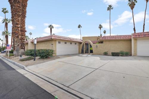 a house with a driveway and palm trees at 2BR 2BA Charming Cathedral City Condo with Territorial Views in Cathedral City