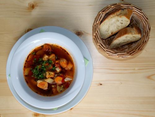 a bowl of soup and a basket of bread on a table at Anna und Sascha, Hotel und Café in Annaberg-Buchholz