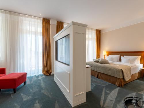 a hotel room with a bed and a television at ROEWERS Privathotel & Spa in Ostseebad Sellin