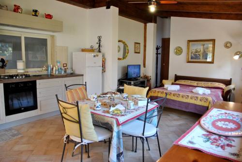 a kitchen and dining room with a table and a bed at La casina di Marta in Formia