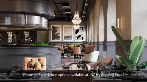 ein Restaurant mit einer Bar mit Stühlen und Tischen in der Unterkunft Jadran Heritage Hotel, Valamar Collection in Poreč