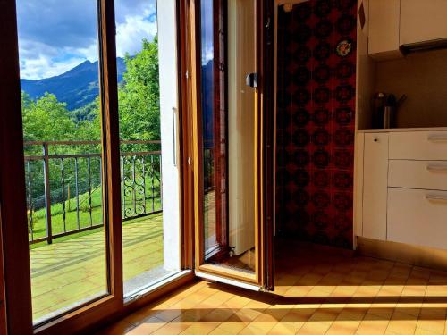 a kitchen with a large glass door with a view at Eco della Valle Apartments by Quokka 360 - with views of the surrounding mountains in Faido