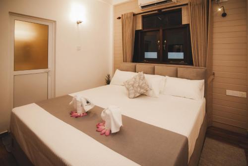 a bedroom with a bed with two dolls on it at Travel Cage in Hikkaduwa