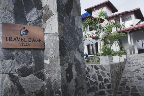 a sign for a travel case villa on a stone wall at Travel Cage in Hikkaduwa